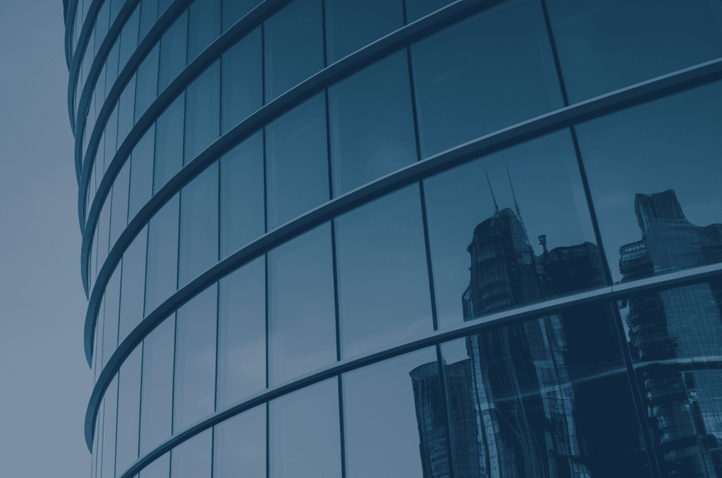 a close-up image of a building with other skyscrapers in the reflection of the windows